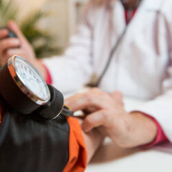 Lääkäri mittaa naisen verenpainetta.