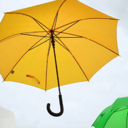 Keltainen sateenvarjo taivaalla.